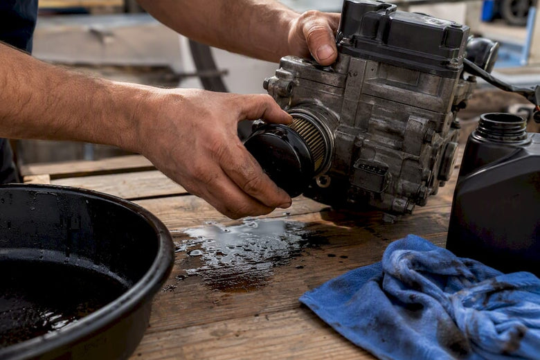 Hands removing Haldex oil filter on workshop bench